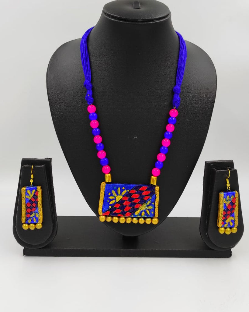 Colorful beaded necklace with matching earrings on a black mannequin against a gray background