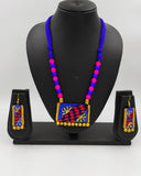 Colorful beaded necklace with matching earrings on a black mannequin against a gray background
