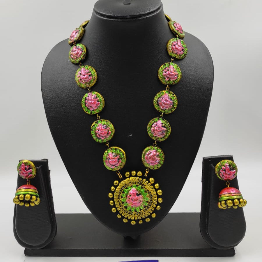 Jewelry set with necklace and earrings on a black mannequin bust against a white background